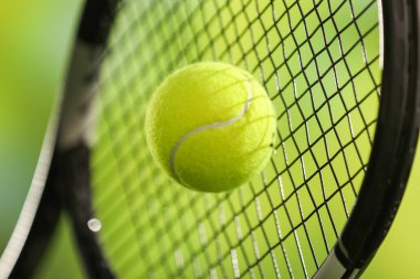 Toplu tenis raketi bulanık yeşil arka planda, yakın plan