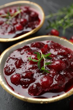 Lezzetli yaban mersini sosu, böğürtlen ve kekik siyah masada, yakın plan.