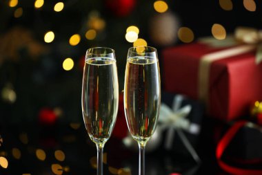Bulanık ışıklara karşı bardakta nefis şampanya, yakın plan. Noel kutlaması