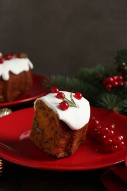 Kırmızı frenk üzümü ve biberiyeyle süslenmiş geleneksel Noel pastası.