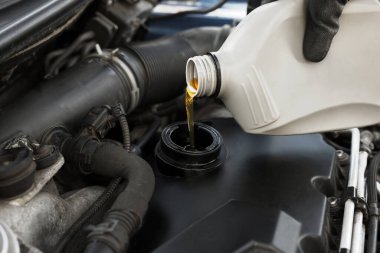 Otomobil motoruna motor yağı döken adam, yakın plan.