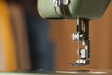 Bulanık arkaplanda ipliği olan klasik dikiş makinesi, makro görünüm. Metin için boşluk
