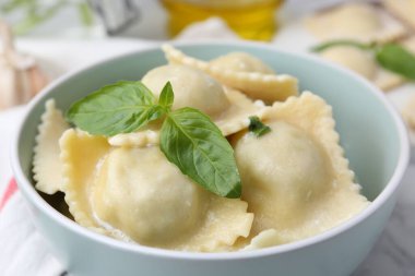 Beyaz masada servis edilen peynirli ve fesleğenli lezzetli ravioli.