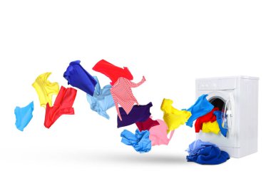 Beyaz arka planda çamaşır makinesinden fırlayan temiz renkli elbiseler.