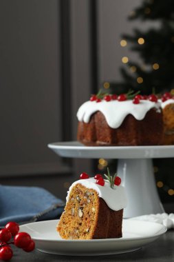 Kırmızı frenk üzümü ve biberiyeyle süslenmiş geleneksel Noel pastası.