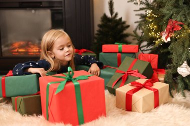 Evde Noel hediyeleri taşıyan küçük kız.