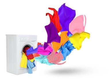 Beyaz arka planda çamaşır makinesinden fırlayan temiz renkli elbiseler.