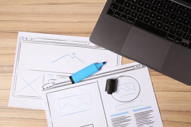 Web sitesi geliştirme. Kablo çizimleri, fosforlu kalem ve dizüstü bilgisayarın tahta masa üzerinde düz konumu.