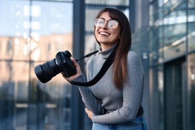 Binanın yakınında dijital kamerası olan profesyonel bir fotoğrafçı.