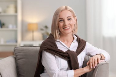 Gülümseyen orta yaşlı bir kadının portresi.