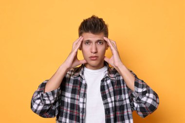 Sınavdan önce sarı arka planda stres yaşayan genç öğrenci