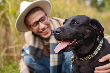 Açık havada sahibi olan sevimli bir köpeğin portresi, seçici bir odak noktası.