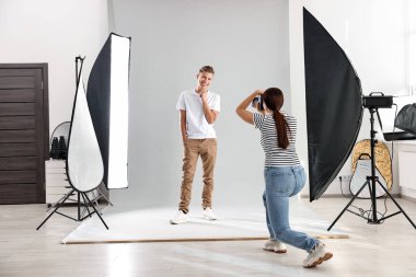 Profesyonel fotoğraf stüdyosunda modelle çalışan bir fotoğrafçı.