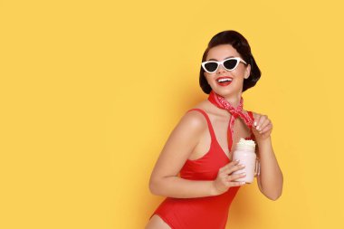 Turuncu arka planda milkshake 'li mayo giymiş kadın, mesaj için yer var.