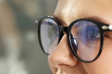 Woman wearing stylish glasses on blurred background, closeup clipart