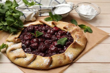 Kiraz, nane ve pudra şekerli ahşap masa.