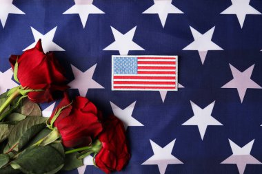 Gaziler Günü. ABD bayrağında Amerikan askeri tarlası ve gül çiçekleri.