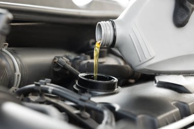 Otomobil motoruna motor yağı döken adam, yakın plan.