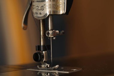 Bulanık arkaplanda iplik ve makro görünümü olan vintage dikiş makinesi