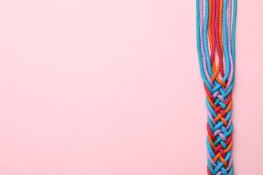 Pembe arka planda örülmüş renkli ipler, yazı için yeri olan üst görünüm. Birlik kavramı