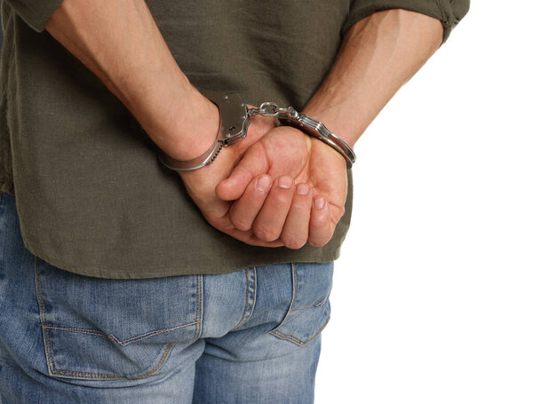 Man in metal handcuffs on white background, back view