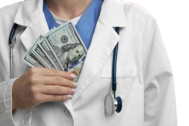 Yozlaşma konsepti. Doktor ceketine dolar banknotları koyuyor, beyaz arka planda, yakın plan.