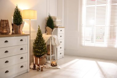 Noel ışıkları ve diğer dekorları olan küçük ladin ağaçları.