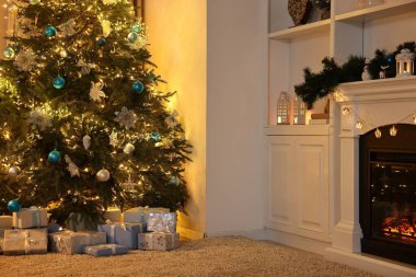 Noel ağacı ve dekore edilmiş şömine. Şenlikli iç mekan