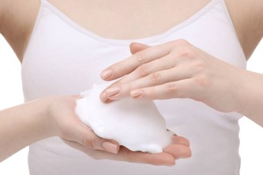 Woman with cleansing foam on hands against white background, closeup