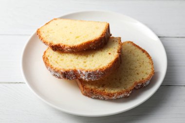 Beyaz ahşap masada taze pişmiş sünger keki.