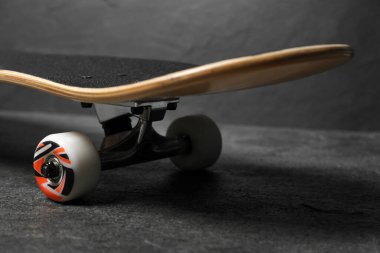 One modern skateboard on grey surface, closeup clipart