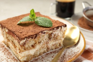 Bir parça lezzetli tiramisu. Masada taze nane var. Yakın plan.