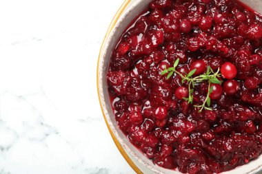 Lezzetli yaban mersini sosu kasede ve kekik beyaz mermer masada, üst manzara. Metin için boşluk