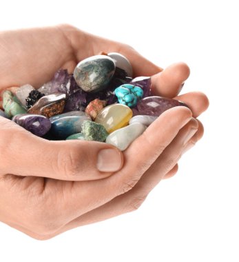 Beyaz arka planda farklı doğal mineral taşları tutan kadın, yakın plan.