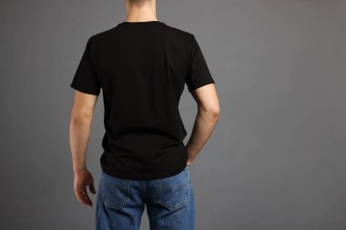 Gri arka planda, şık tişörtlü bir adam. Tasarım için model