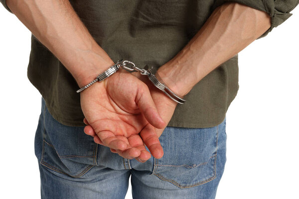 Man in metal handcuffs on white background, back view