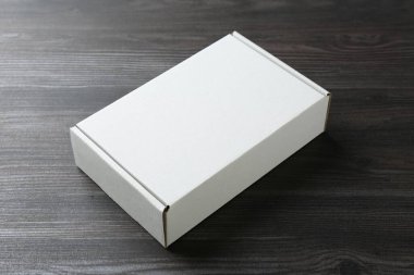 Ahşap arka planda boş bir karton kutu. Tasarım için model