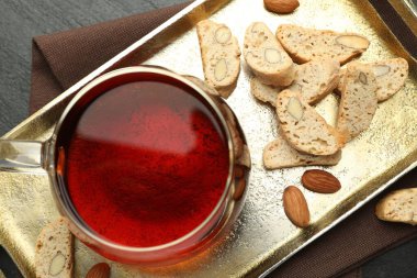 Geleneksel İtalyan badem bisküvileri (Cantucci), fındık ve bir fincan çay gri masada, düz yatıyordu.