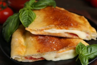 Mozarella, domates ve fesleğenli lezzetli calzone pizzası.