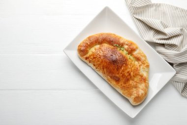 Beyaz ahşap masada nefis taze calzone pizza, üst manzara. Metin için boşluk