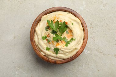 Kırmızı biberli enfes humus ve gri arka planda maydanoz.