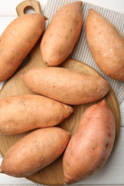 Beyaz ahşap masada taze çiğ patates, üst manzara.