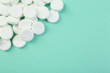 Turkuaz arka planda antibiyotik hapları yığını, üst görünüm. Metin için boşluk