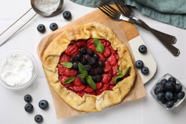 Böğürtlenli, nane ve pudra şekerli leziz bir galet beyaz fayanslı masa, düz yatıyordu.