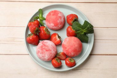 Delicious mochi, strawberries and mint on wooden table, top view clipart