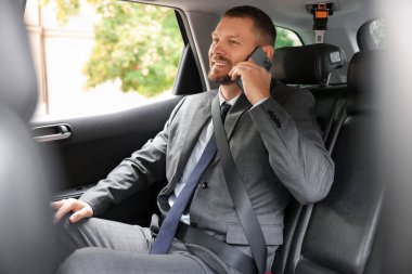 Modern arabada telefonla konuşan mutlu bir adam.