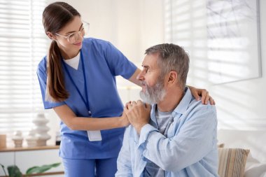 Bakıcı içeride kıdemli adamı destekliyor. Ev sağlık hizmetleri