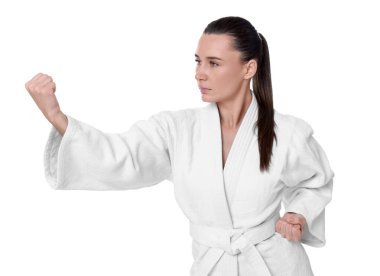 Kimonolu genç bir kadın beyaz arka planda karate yapıyor.