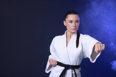 Koyu mavi arka planda kimonolu karate dövüşçüsü, metin için boşluk
