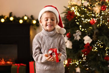 Evde Noel süsü takan küçük çocuk.